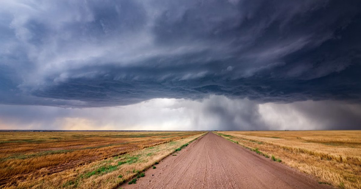 Kansas storm brewing in distance over a dirt road