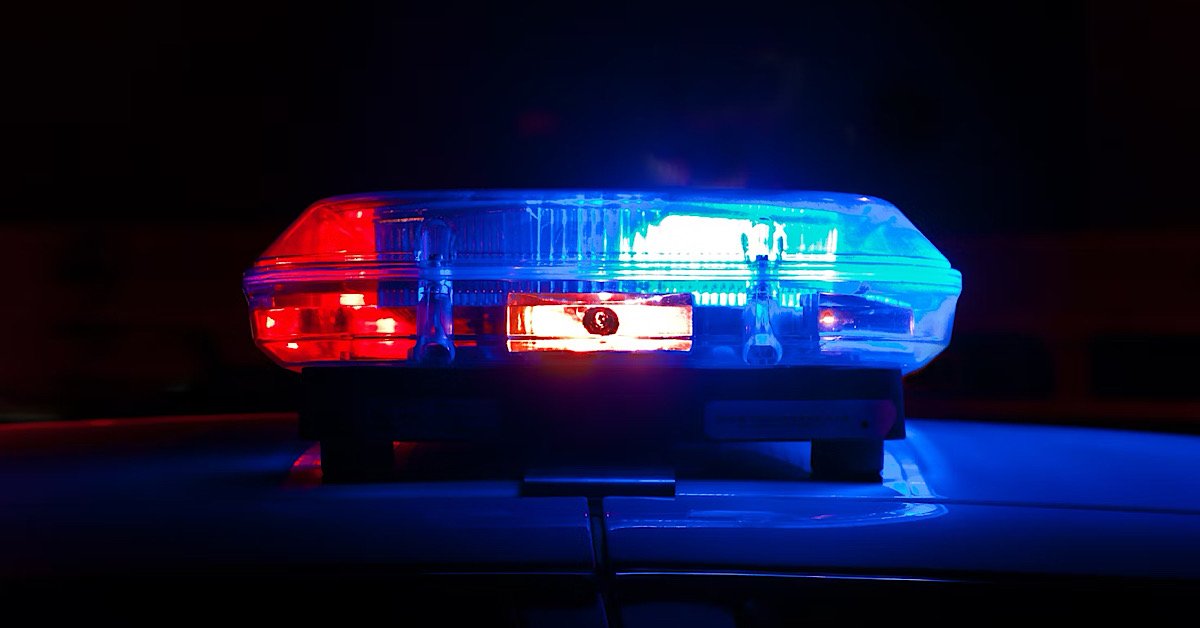 Flashing police car lights on Texas road representing DUI and insurance consequences